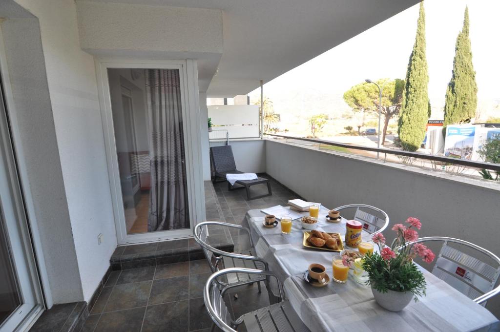 stół z jedzeniem na balkonie w obiekcie RNET - 130 Portomar Standart Roses w mieście Roses