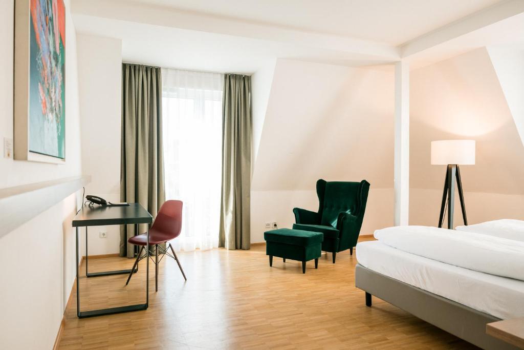 a hotel room with a bed and a desk and a chair at Hotel Trezor in Singen