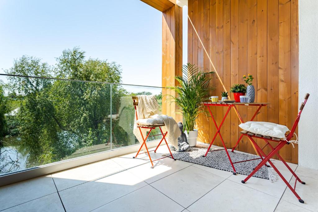 a patio with two chairs and a table on a balcony at Il Lago - Sunrise - Cozy Luxurious Smart Home By The Lake in Voluntari
