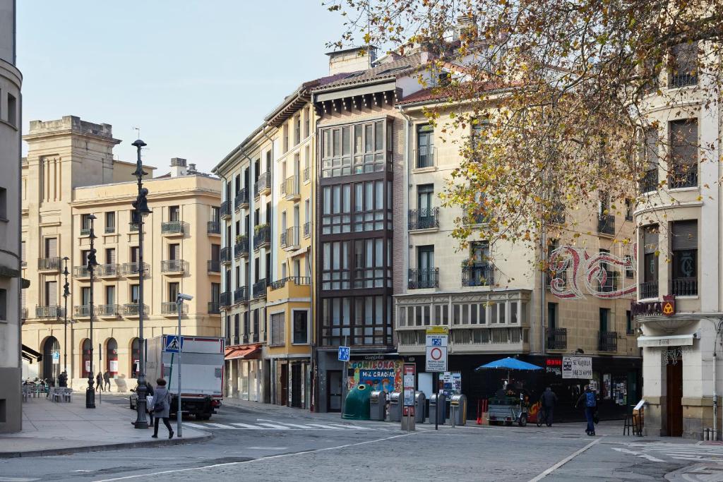 une rue urbaine avec des bâtiments et des gens qui marchent dans la rue dans l'établissement Pamplonapartments Duque de Ahumada, à Pampelune