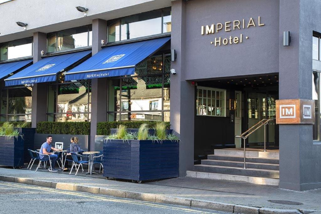 un hombre sentado en una mesa fuera de un hotel en Hotel Imperial Dundalk, en Dundalk