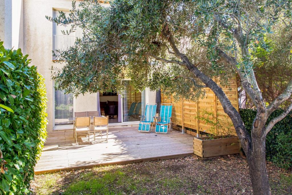 una terrazza in legno con 2 sedie e un albero di Calm and sunny AC house with terrace and garden in Antibes - Welkeys a Antibes