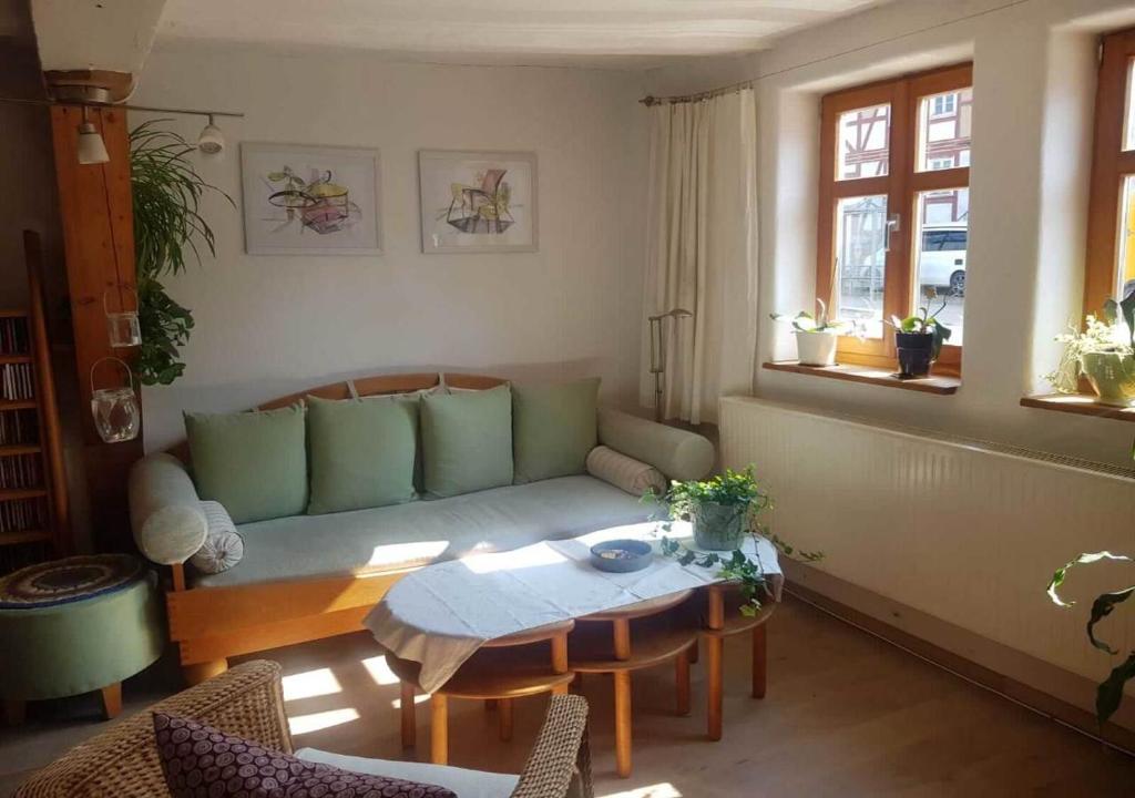 een woonkamer met een bank en een tafel bij Ältestes Haus in Quentel - Ferienwohnung 1 mit kleinem Garten in Lichtenau