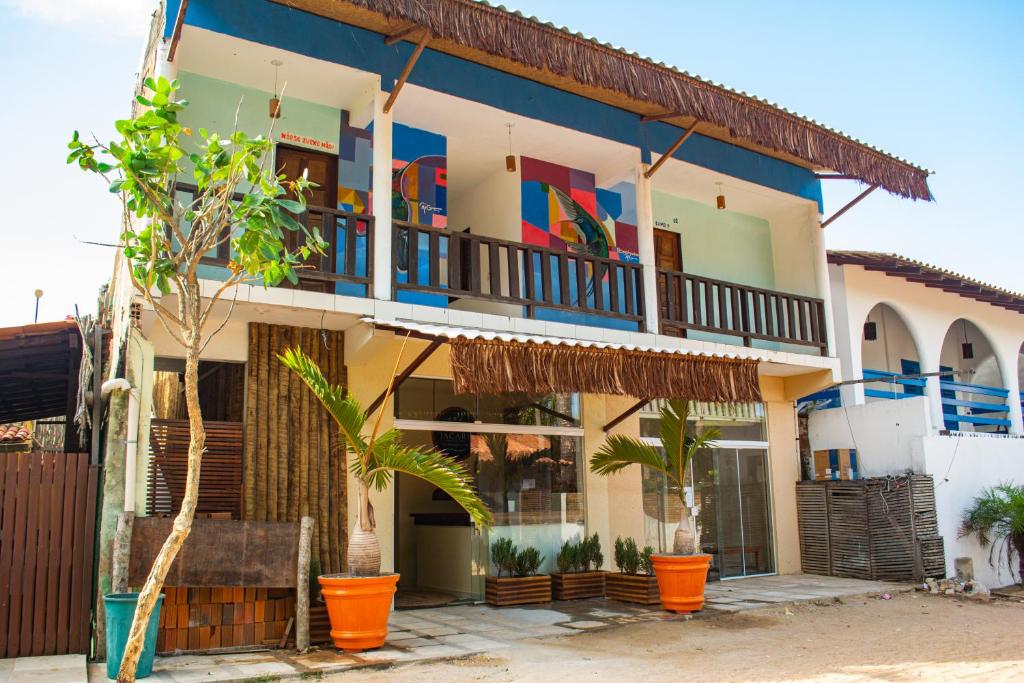 um edifício de apartamentos com varandas coloridas e palmeiras em Pousada Numei de Jeri em Jericoacoara