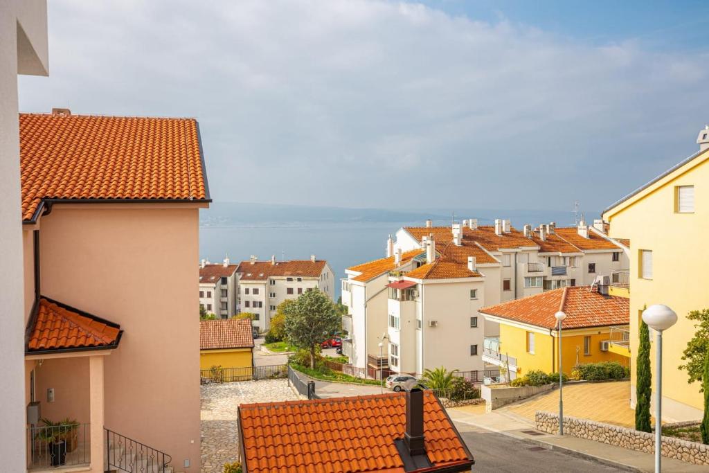 uitzicht op een stad met gebouwen en de oceaan bij Apartments Michelle in Crikvenica