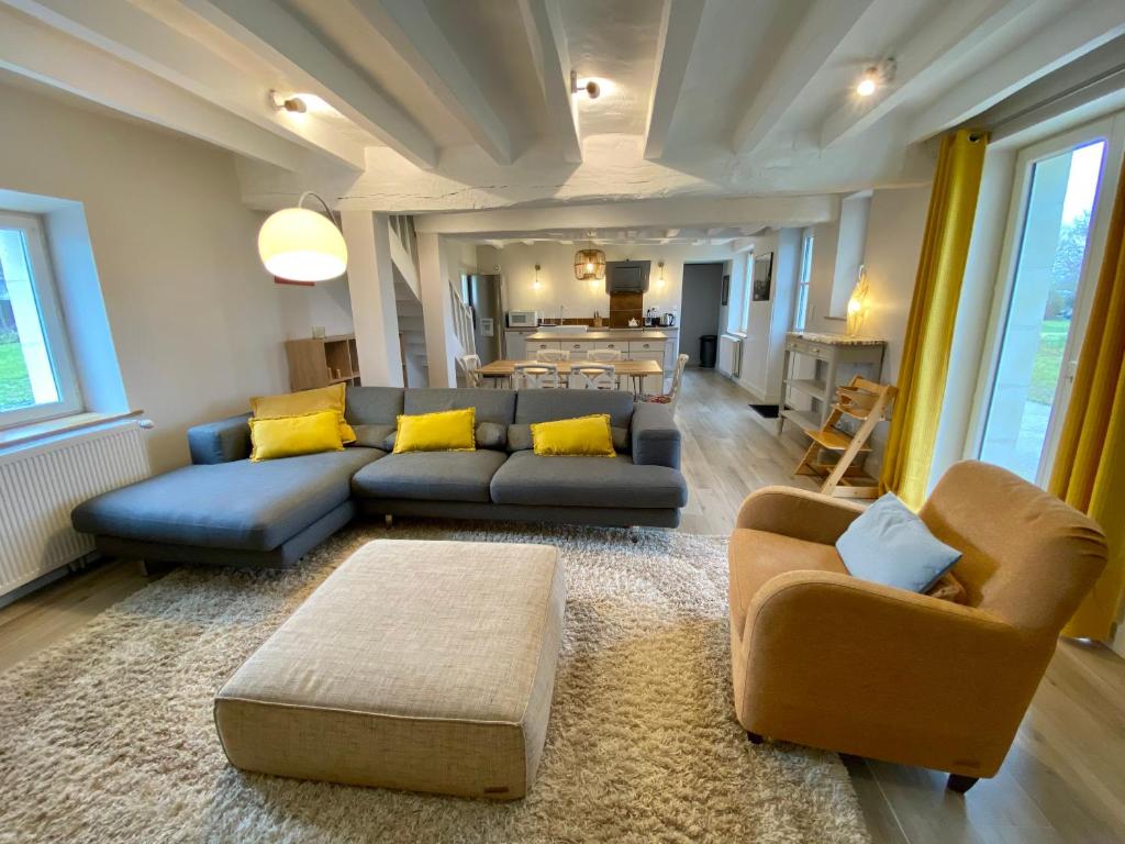 a living room with a blue couch and yellow pillows at A L&#39;OMBRE DU TILLEUL nature campagne charme confort in Saint-Branchs