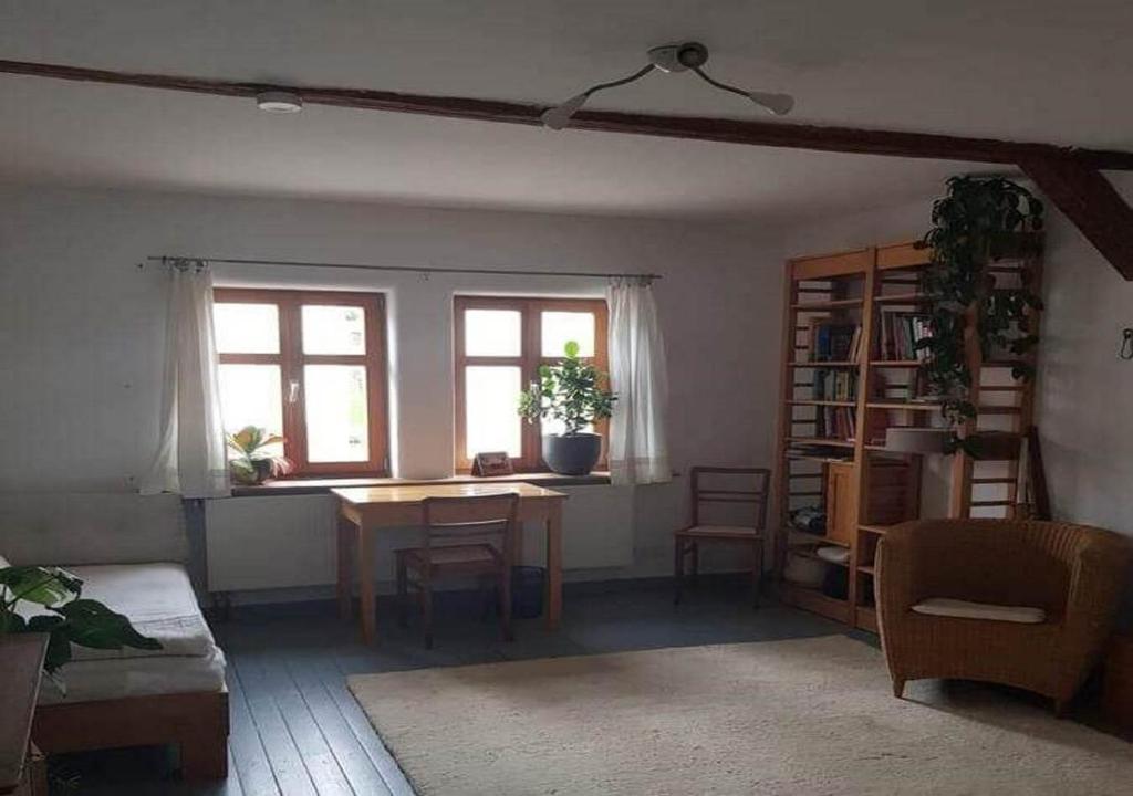 sala de estar con mesa y 2 ventanas en Ältestes Haus in Quentel - Ferienwohnung 2 mit Dachterrasse, en Lichtenau