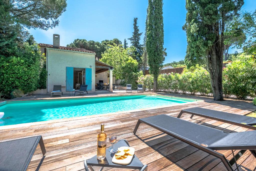 - une piscine avec une terrasse et une maison dans l'établissement La Tropézienne - Welkeys, à Saint-Tropez