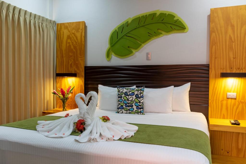 dos cisnes en toallas blancas sentados en una cama en Apartamentos Equipados RyA del Volcán, en Fortuna