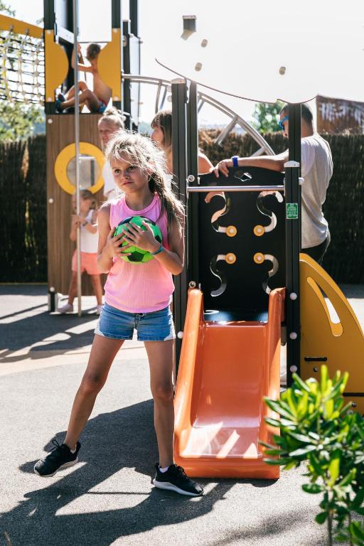 a young girl is playing on a playground at Camping Tucan - Mobile Homes by Lifestyle Holidays in Lloret de Mar