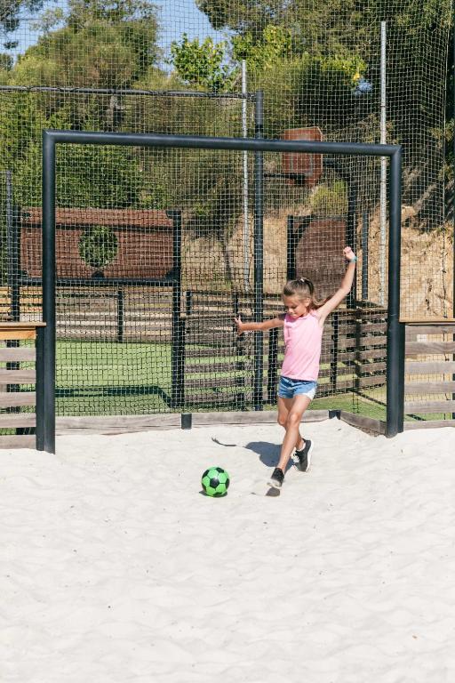 a little girl playing with a soccer ball in the sand at Camping Tucan - Mobile Homes by Lifestyle Holidays in Lloret de Mar