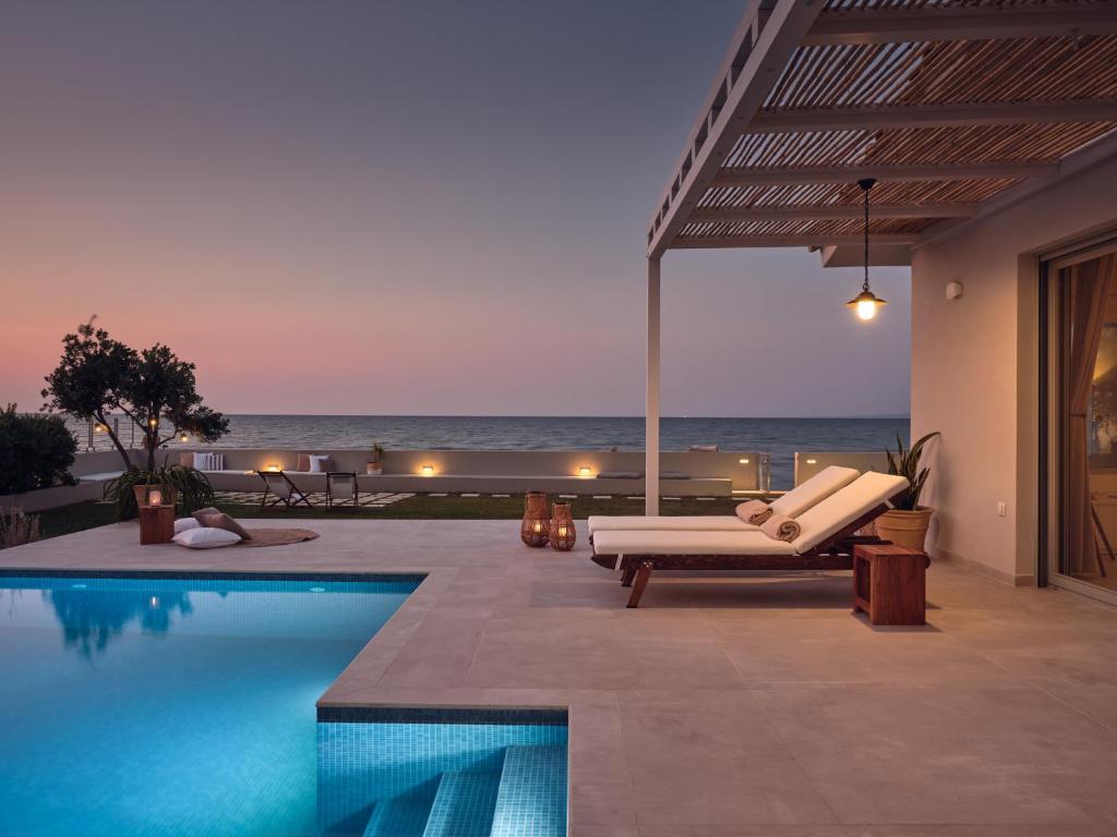 アルガッシにあるAstarte Villas - Onda Beach Villaの海の景色を望むスイミングプール付きのヴィラです。