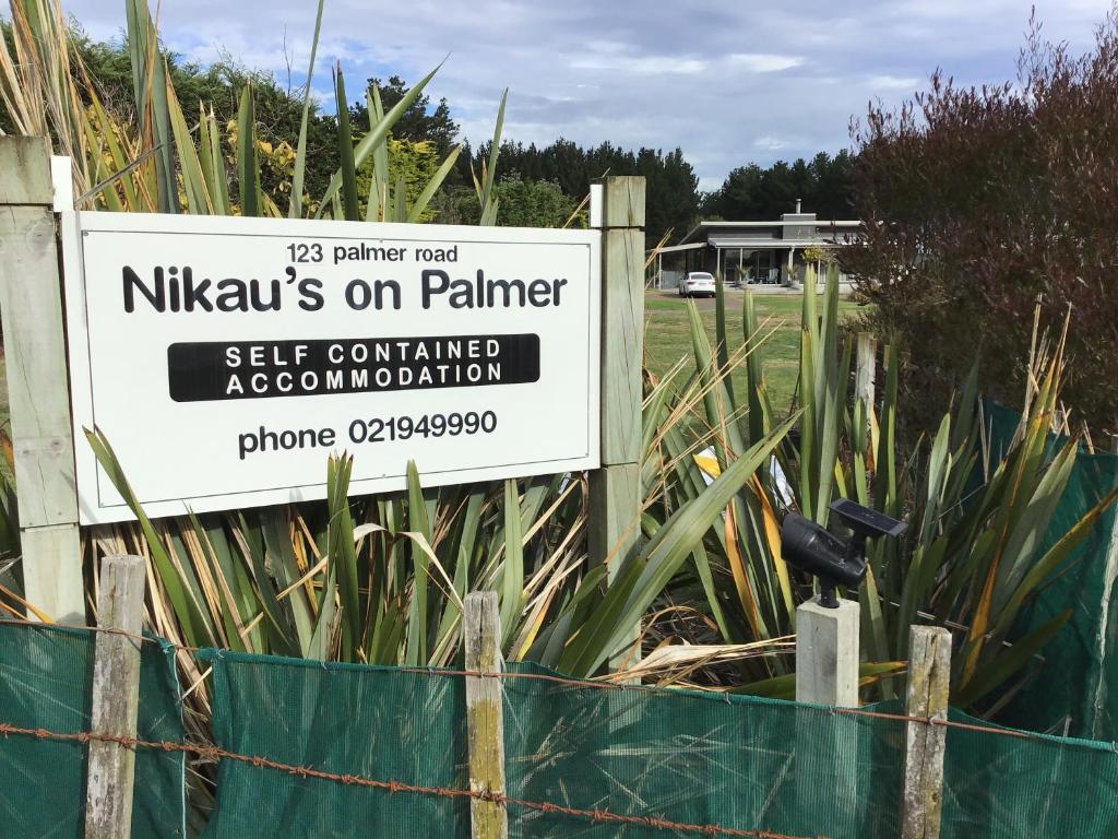 a sign for a nkalis on palmer on a fence at Nikau’s on Palmer in Foxton Beach