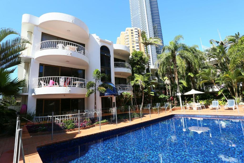 um hotel com piscina em frente a um edifício em St Tropez Resort em Gold Coast