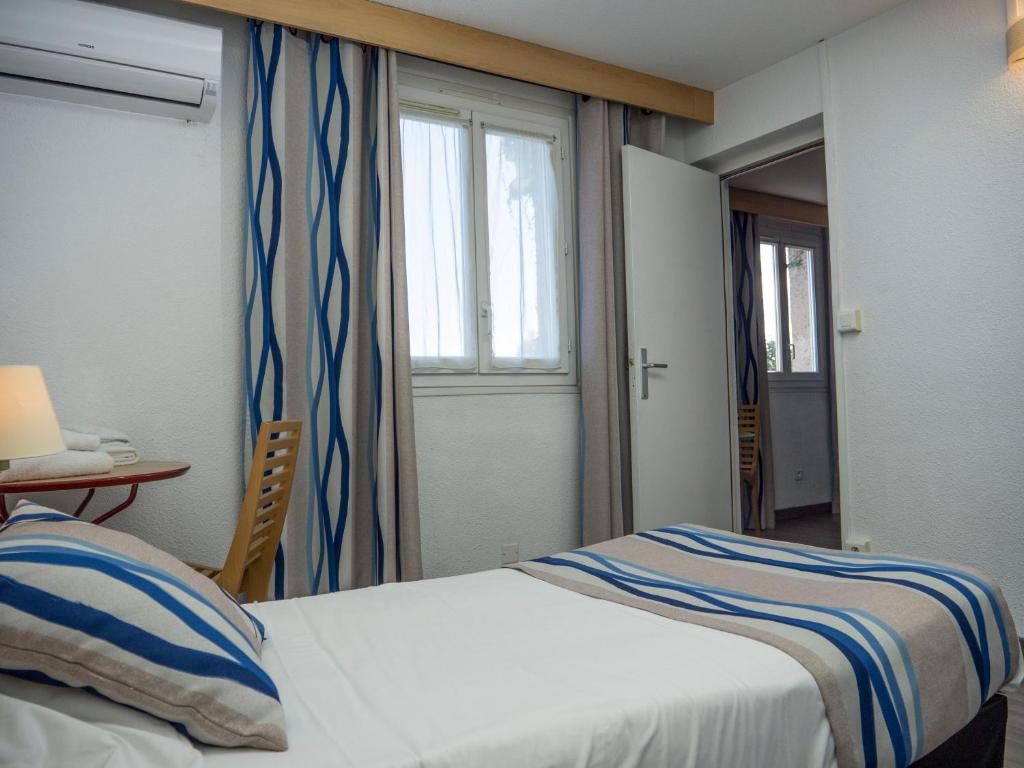 Postel nebo postele na pokoji v ubytování Logis Hotel Restaurant Uzès Pont du Gard