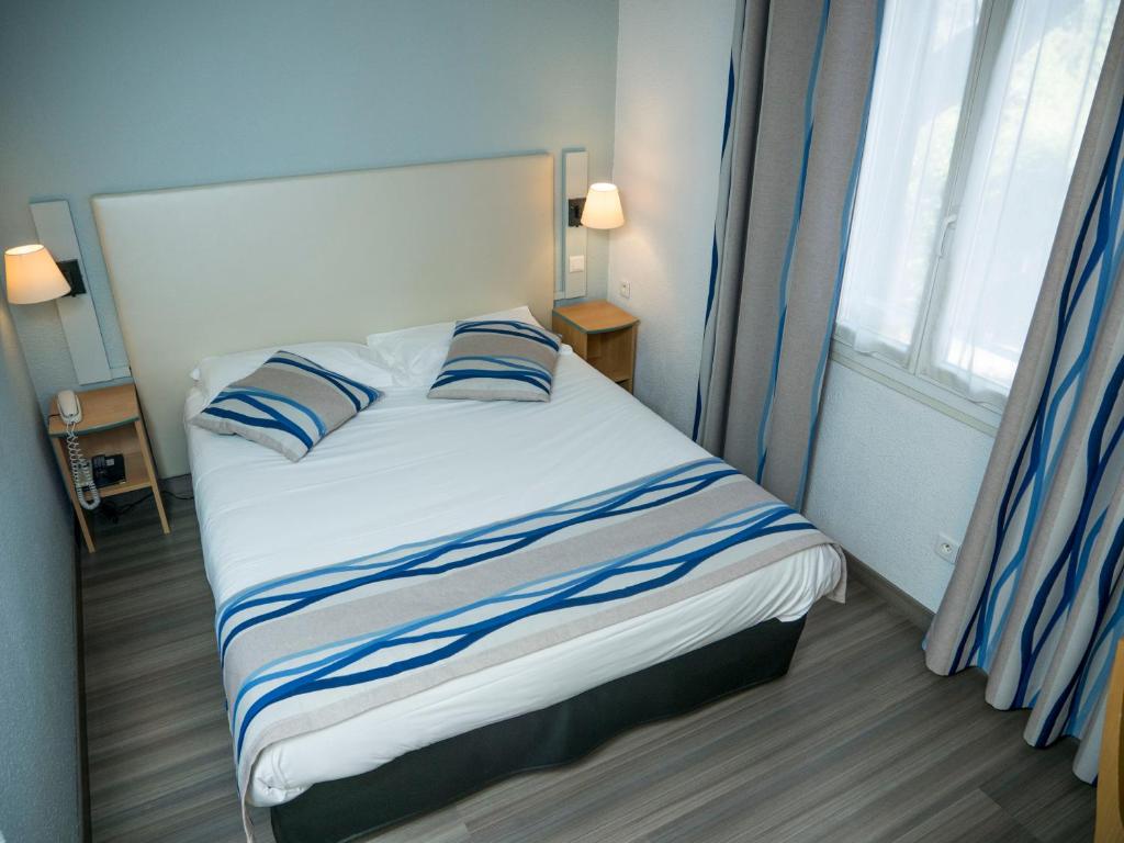 Postel nebo postele na pokoji v ubytování Logis Hotel Restaurant Uzès Pont du Gard