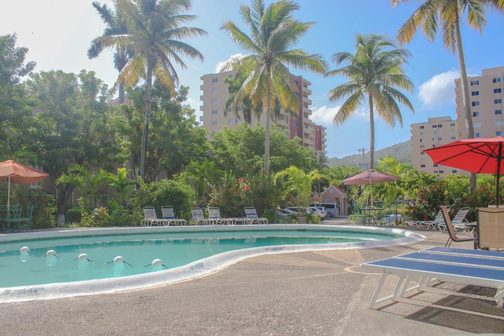 a swimming pool with ducks in the water with palm trees at Fisherman Point Beach Resort in Ocho Rios