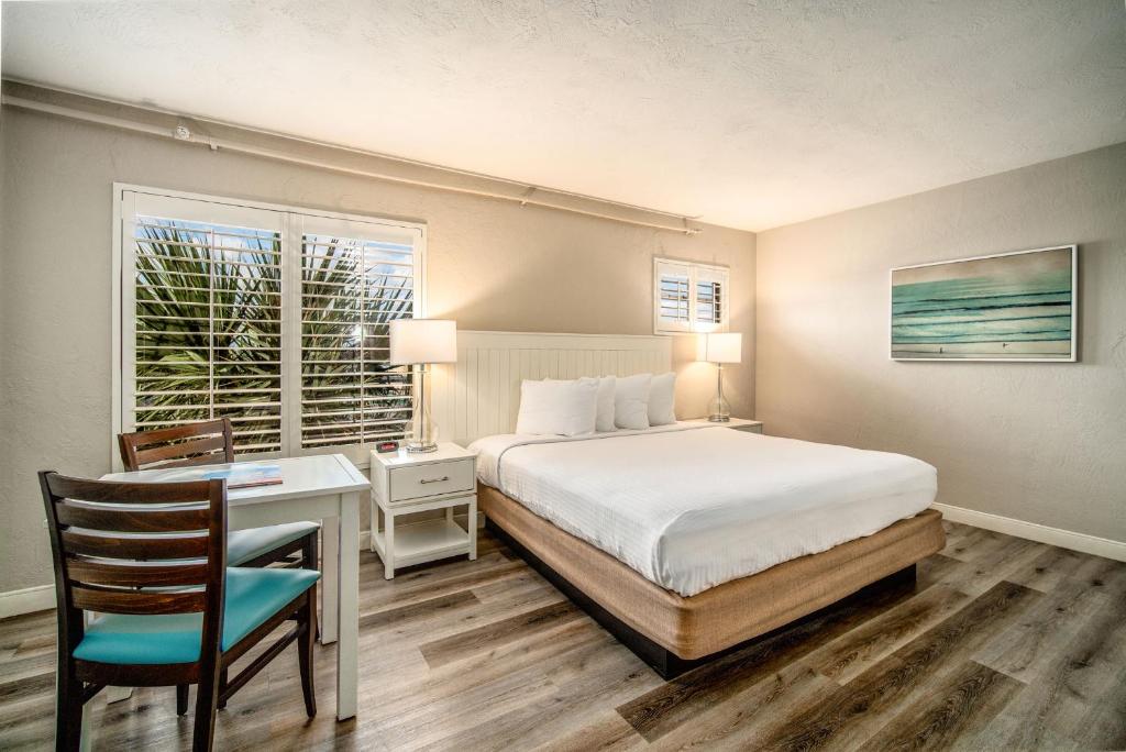 a bedroom with a bed and a desk and a window at Perry's Ocean-Edge Resort in Daytona Beach