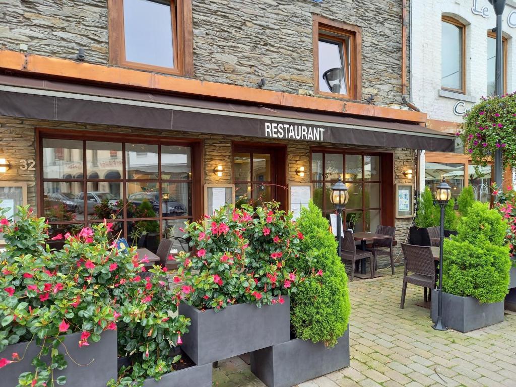 een restaurant met bloemen voor een gebouw bij Hebergement confort Comfortlogies La Fontanella in La-Roche-en-Ardenne