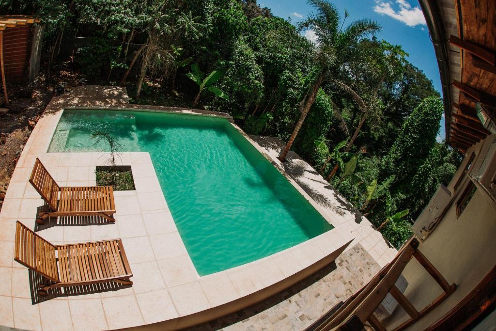 an overhead view of a swimming pool with two deck chairs and sidx sidx at Botánica Iguazú The House Experience in Puerto Iguazú