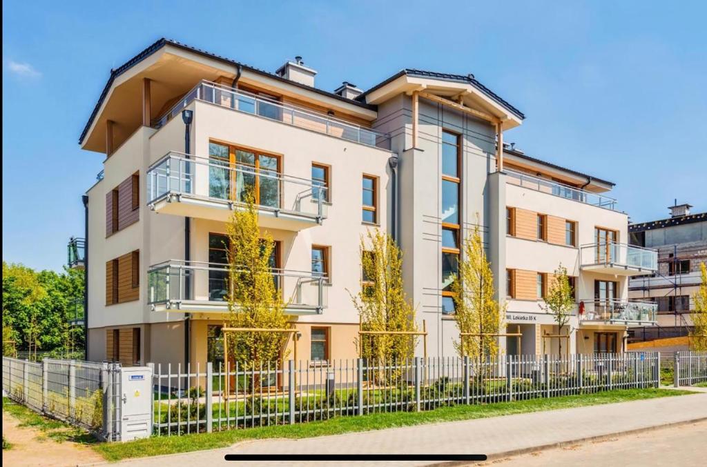 an apartment building with a fence in front of it at Urus Home Sopot in Sopot