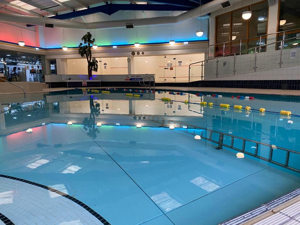 a large swimming pool with blue water in a building at Brook Mollington Banastre Hotel & Spa in Chester