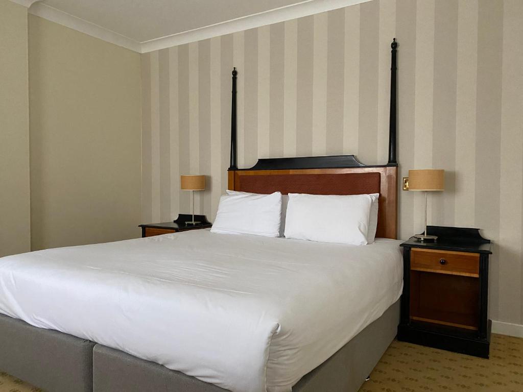 a hotel room with a bed and a lamp at Brook Mollington Banastre Hotel & Spa in Chester