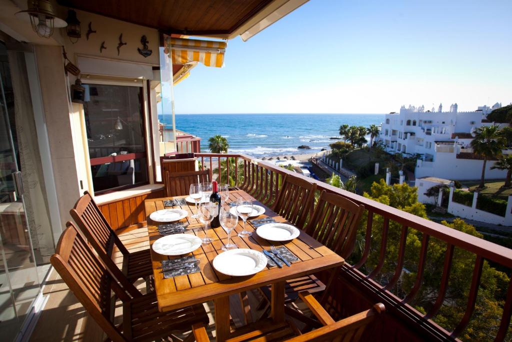 una mesa en un balcón con vistas al océano en Apartamento Lubina del Sol. 1ª linea de playa - By the Sea, en Mijas Costa