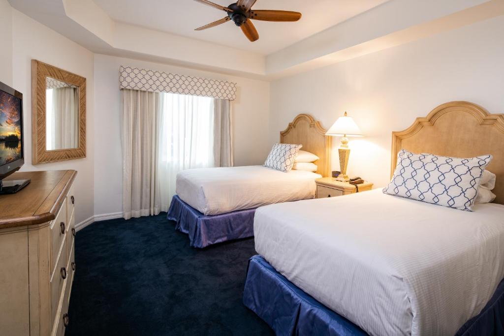 a hotel room with two beds and a ceiling fan at Bellasera Resort in Naples