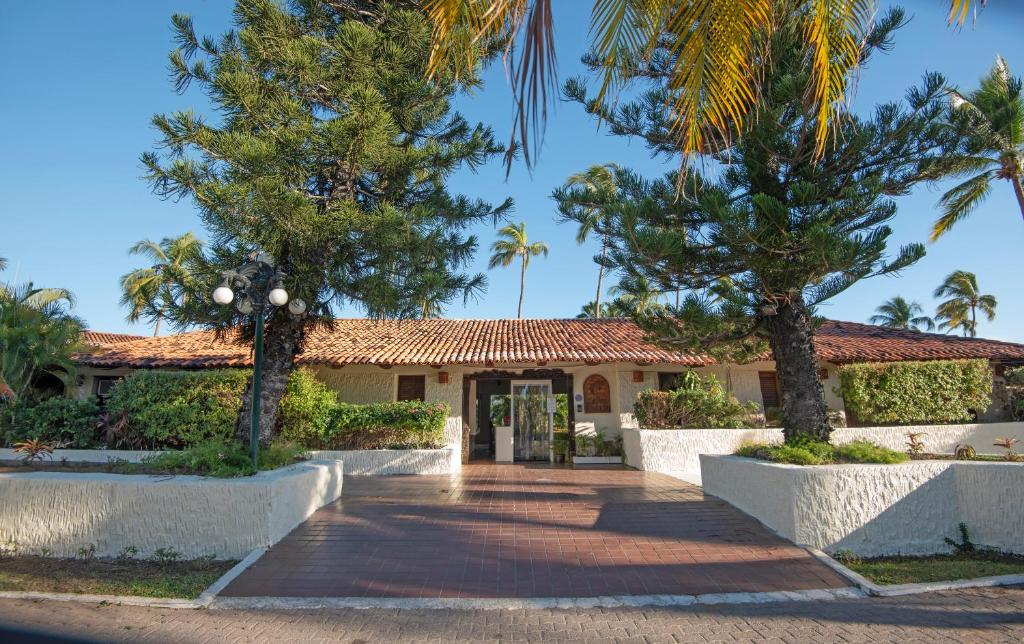 巴拉德纳维达Cabo Blanco Hotel and Marina的棕榈树房屋和车道