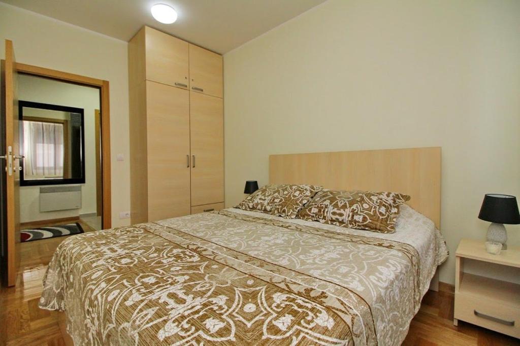 ein Schlafzimmer mit einem großen Bett und einer Kommode in der Unterkunft Apartment Adam-Zlatiborska Vila I in Zlatibor