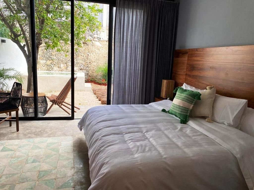 um quarto com uma cama grande e uma janela grande em Hotel Unknown em Mérida