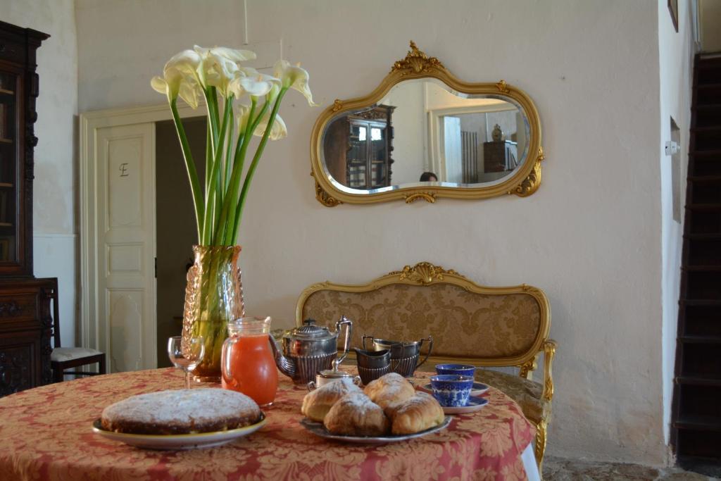 uma mesa com pão e um vaso com espelho em Casale Rocca Fiorita em Acate