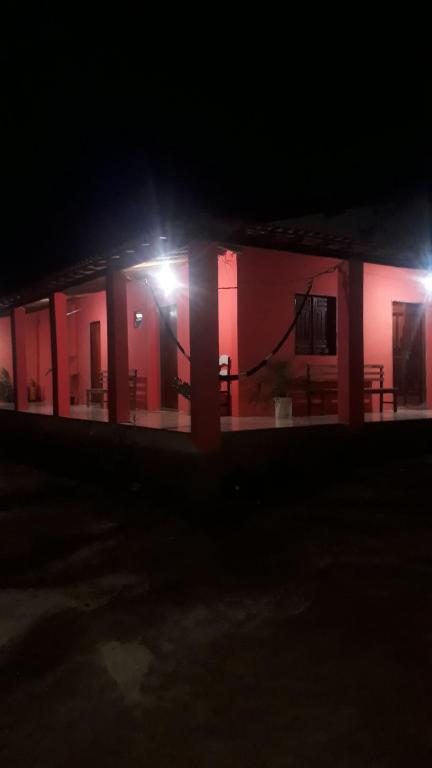 a building with red walls and lights at night at Hospedagem Flor de Araca in Ibicoara