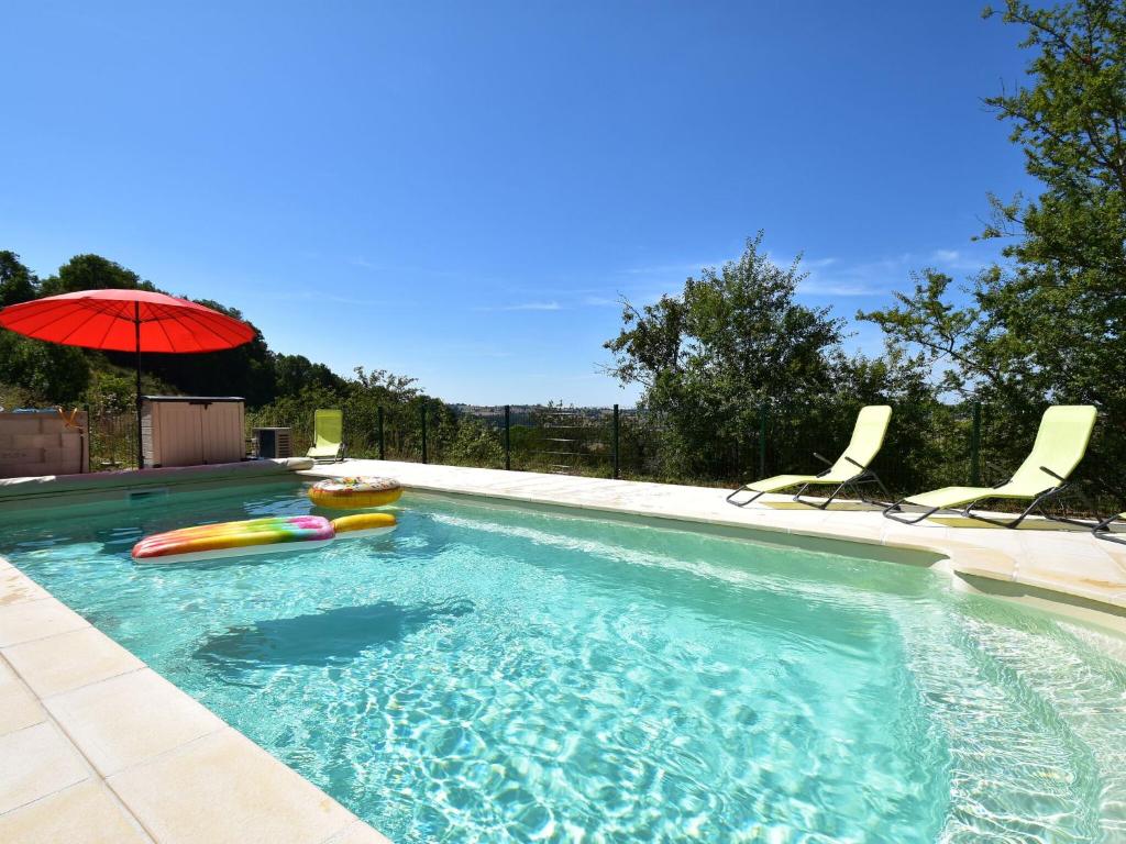a swimming pool with two chairs and an umbrella at Attractive holiday home in Cuzy with pool in Cuzy