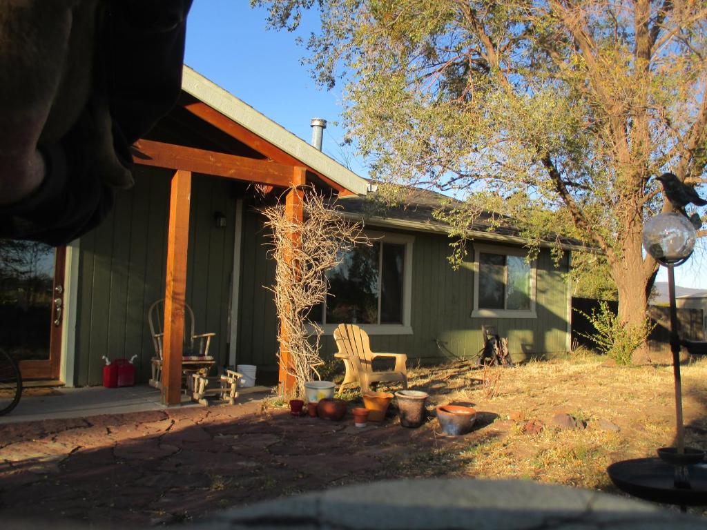 a green house with a dog sitting in front of it at Peaks Wildernest House Bed and Breakfast - Vaccinations Required in Flagstaff