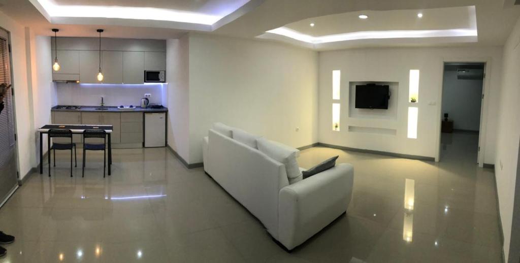 a living room with a white couch and a kitchen at Apto T1 Sweet Home in Praia