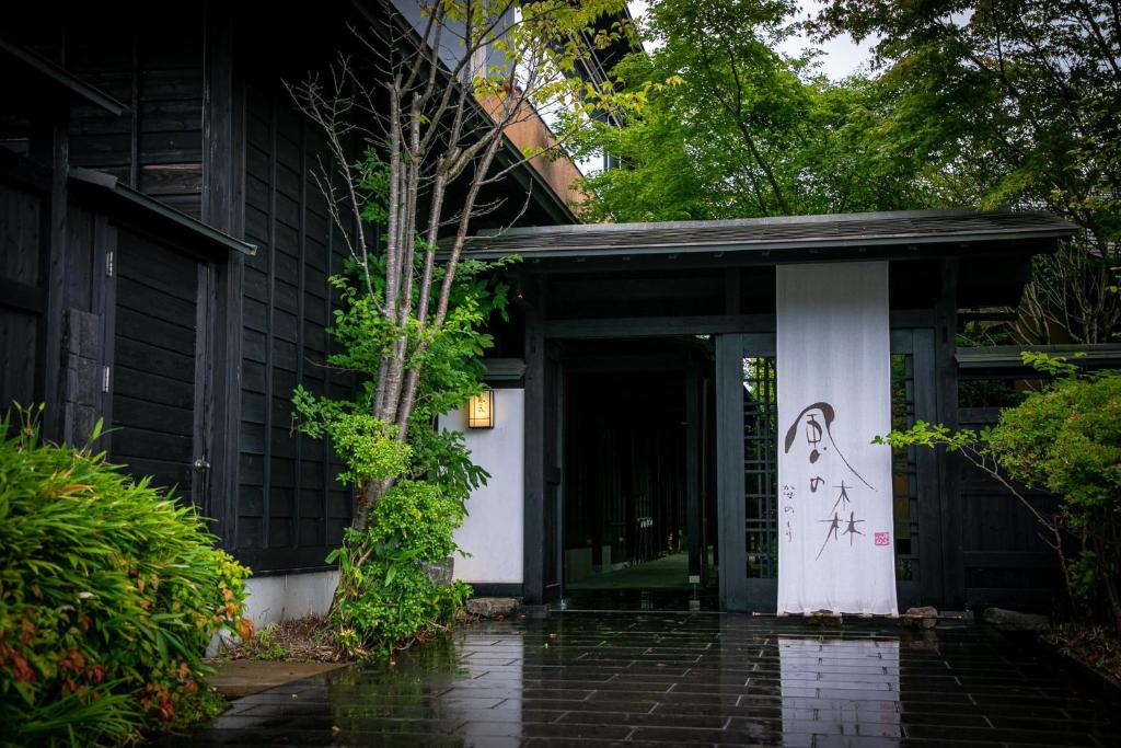 une porte d'entrée d'une maison munie d'un panneau. dans l'établissement Yufuin Kaze no Mori, à Yufu