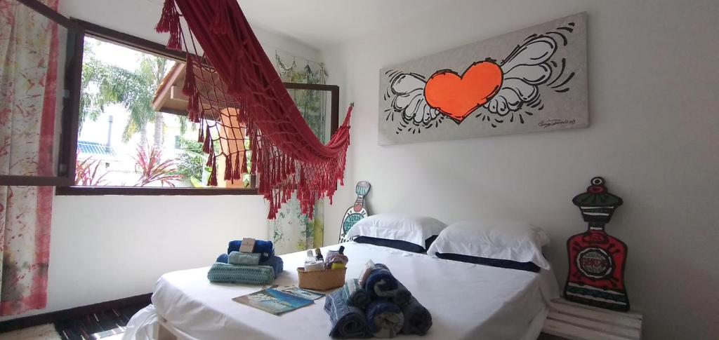 1 dormitorio con 1 cama con una foto del corazón en la pared en Loft-Atelier 100m praia, en Florianópolis