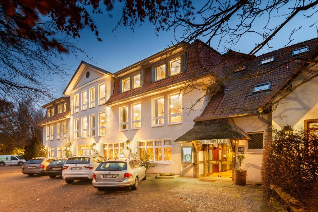 una casa grande con coches estacionados frente a ella en Hotel & Restaurant Grotehof, en Minden