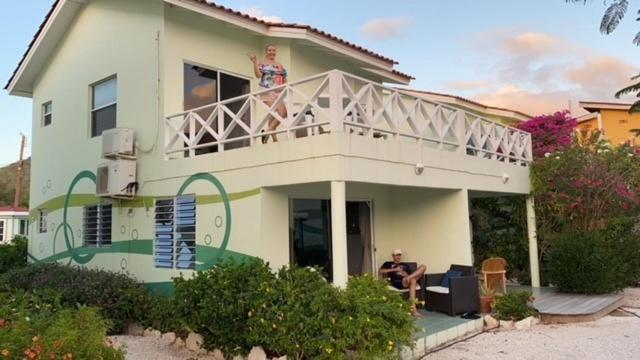 a woman standing on the balcony of a house at Blue Lagoon Apartment in Lagun