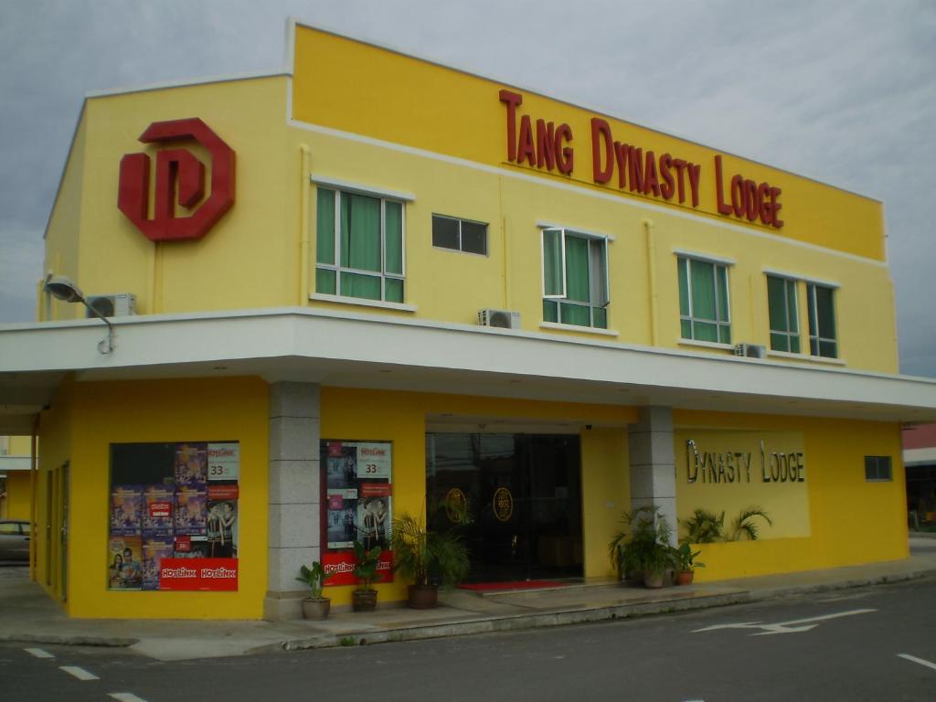a yellow building with a sign on top of it at Tang Dynasty Lodge Tuaran in Tuaran