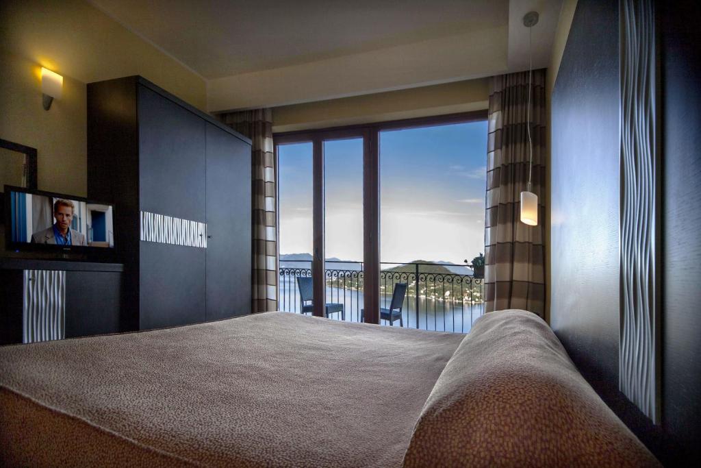 a bedroom with a bed with a view of the ocean at Hotel Ristorante San Carlo in Arona