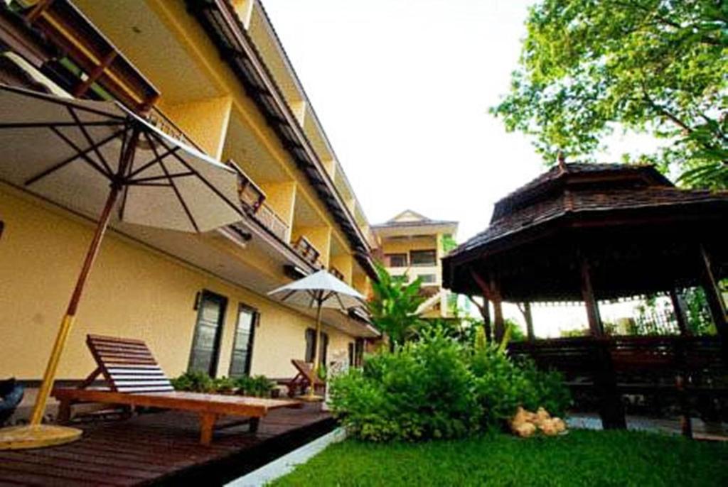 萊卡邦的住宿－素帆湖別墅酒店，一座带长凳和遮阳伞的庭院的建筑