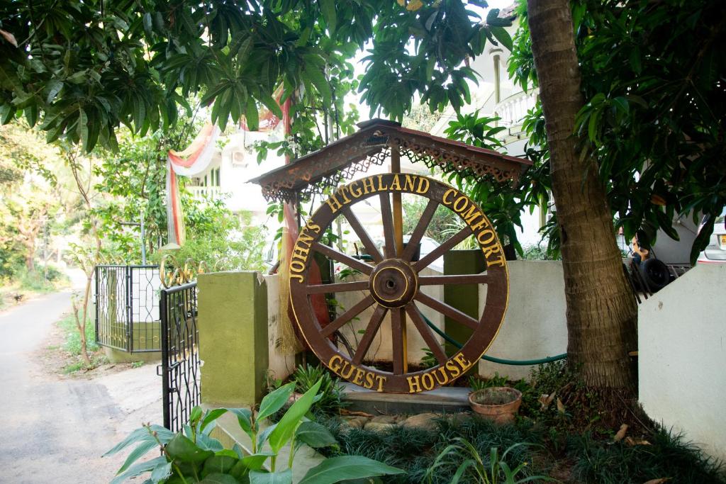 a large woodenoked wheel in front of a building at John's Highland Comfort (Guest House) in Majorda