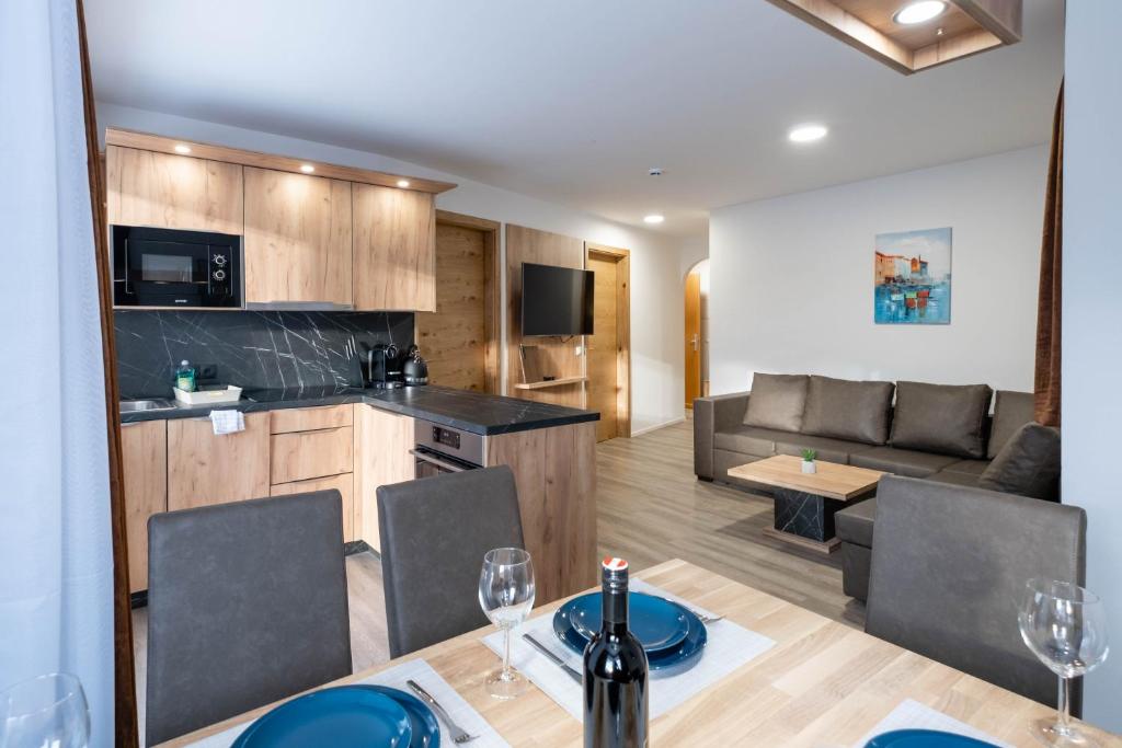 eine Küche und ein Wohnzimmer mit einem Tisch und Stühlen in der Unterkunft Apartments Maiskogelblick in Piesendorf