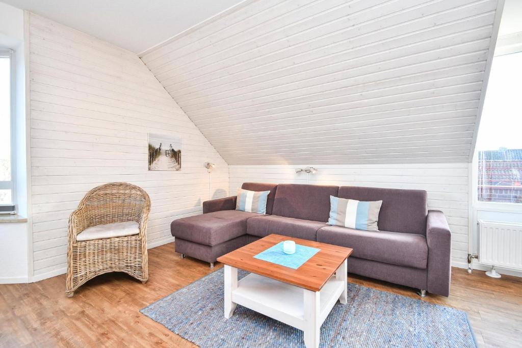 ein Wohnzimmer mit einem Sofa und einem Tisch in der Unterkunft Hamburger Straße 11 Wohnung D in Kellenhusen