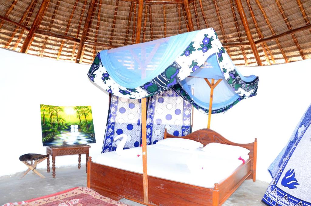 a bedroom with a bed with a blue canopy at Funky Squids Beach Resort in Bagamoyo