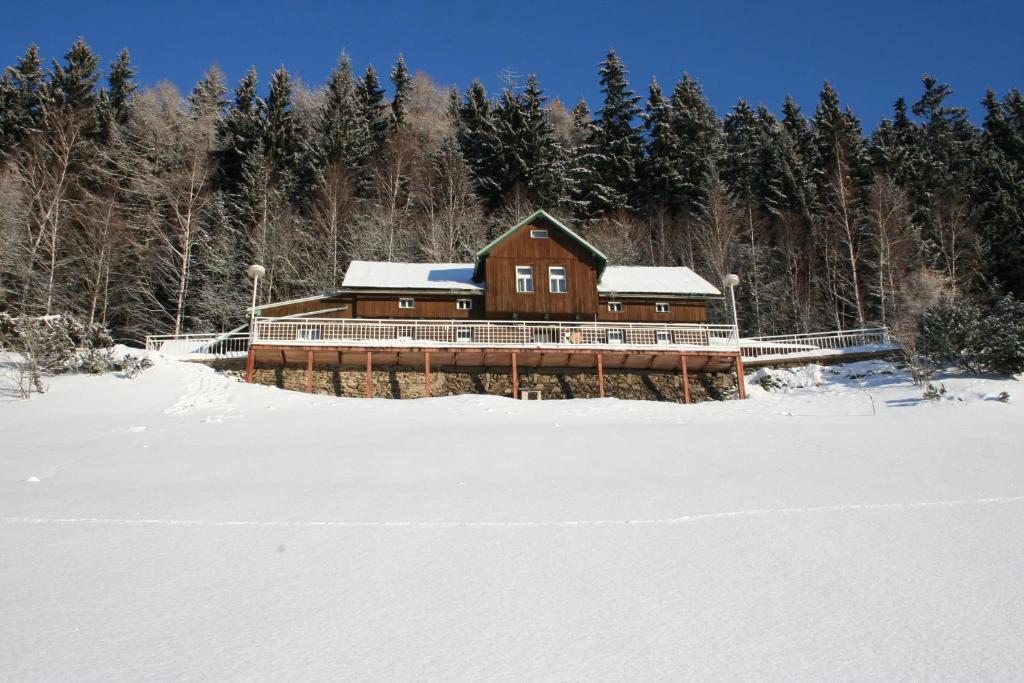 a house in the snow in front of trees at Penzion Táňa in Pec pod Sněžkou