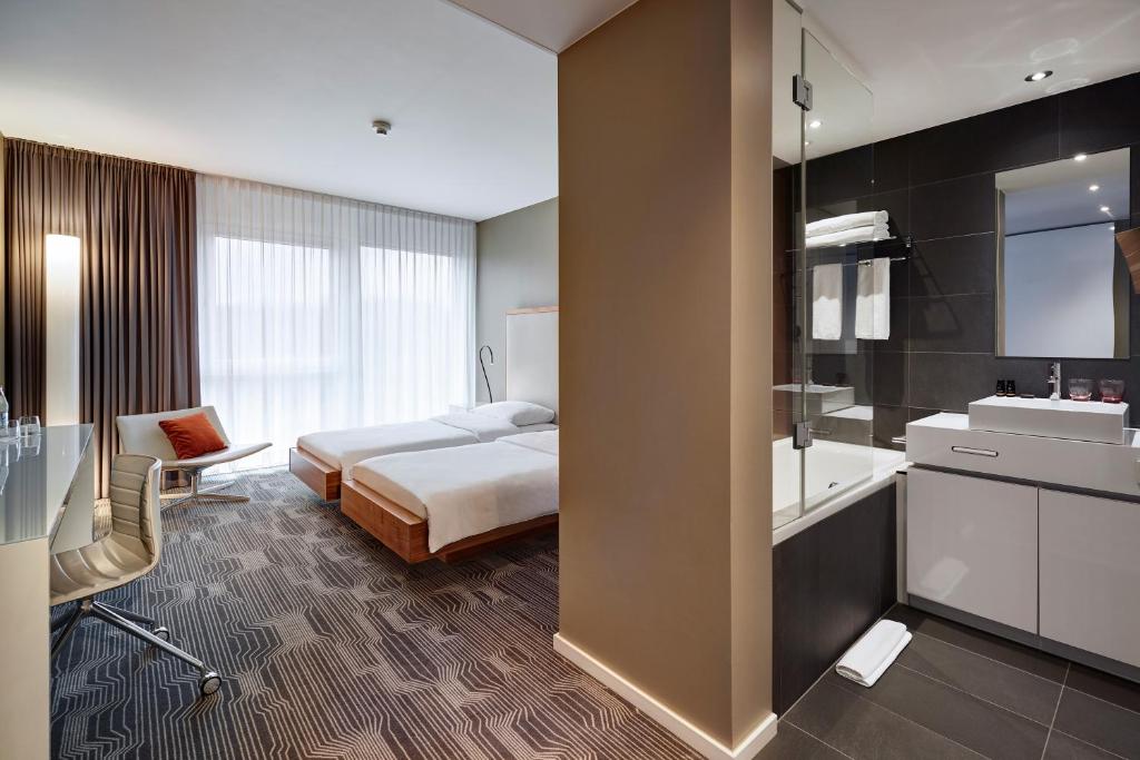 a hotel room with a bed and a bathroom at LÉGÈRE HOTEL Luxembourg in Luxembourg